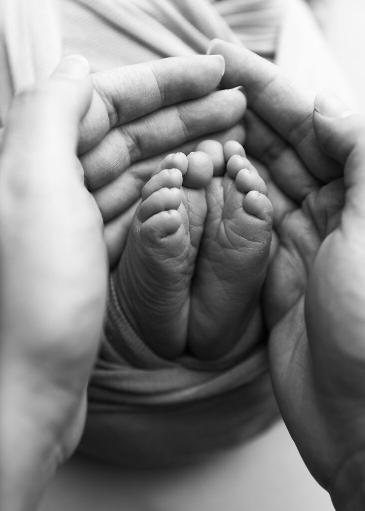 An infant's feet cradled gently in an adult's hands.
