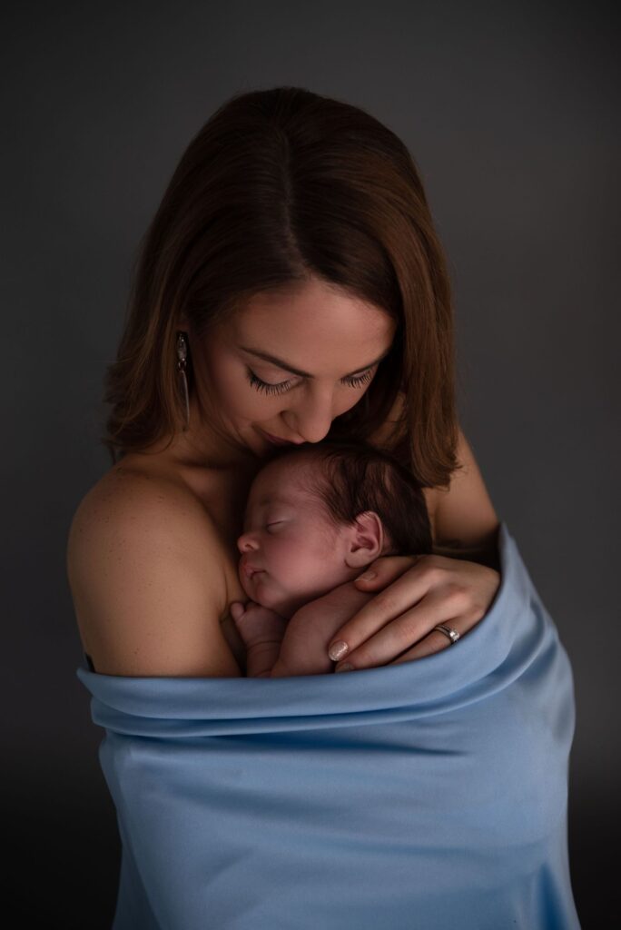 A mother cradling her newborn baby with tenderness.